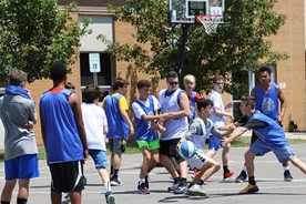 A group of students compete in a Hilbert College basketball athletic camp.